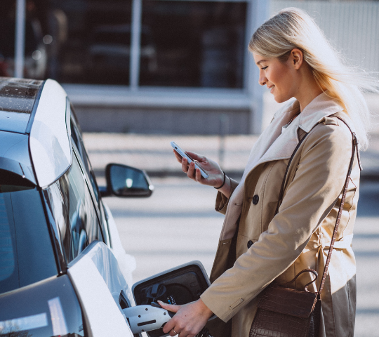 En kvinna laddar elbilen